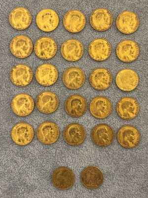 a pile of old gold coins on a gray surface