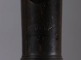a close up of a metal object with a black handle