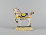 a figurine of a horse with a saddle on it ' s back