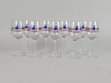 six verres à vin sont alignés sur une surface blanche