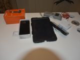 a table with a cell phone and other electronics on it