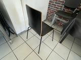 une chaise noire posée devant un mur de briques