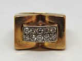 une image d'une bague en or avec des diamants sur une surface blanche