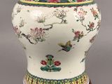 a white vase with flowers and birds painted on it
