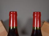 two bottles of wine sitting next to each other on a table