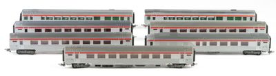 three silver and red train cars sitting next to each other on a white surface