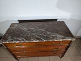 a marble top chest of drawers in the corner of a room