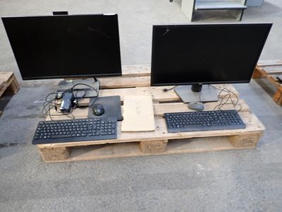 two computer monitors and a keyboard on a pallet