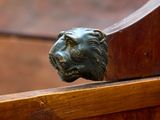 a close up of a lion ' s head on a wooden bench