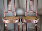 paire de chaises anciennes en bois avec des assises en osier sur un fond gris