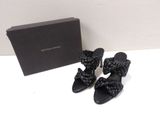 the black sandals are next to a black box on a white surface