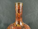a vase with a floral design on it sitting on a table