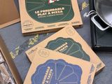 several boxes of pizza sitting on top of a table next to a pan