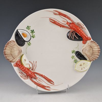 une assiette sur laquelle se trouvent un homard, des crevettes et un citron