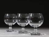 trois verres à vin vides sont alignés sur une table