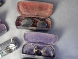 several pairs of glasses in a case on a table