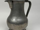 an old silver coffee pot with a bird on the top