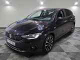 la voiture noire est garée sur un sol en damier dans le garage