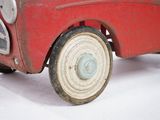 a red toy car that is sitting on a white surface