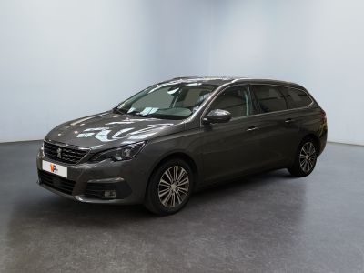 a grey car is parked in a room with a white wall