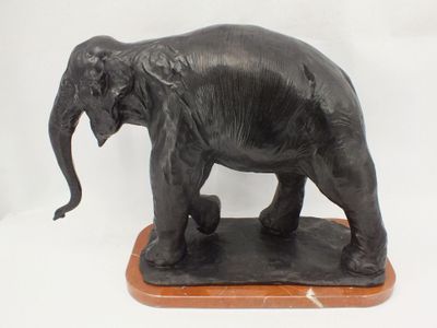 statue of an elephant standing on a wooden base on a white background