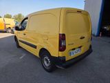 yellow van parked in a parking lot with other vehicles in the background