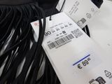 a black bag with a price tag on it next to some black cords