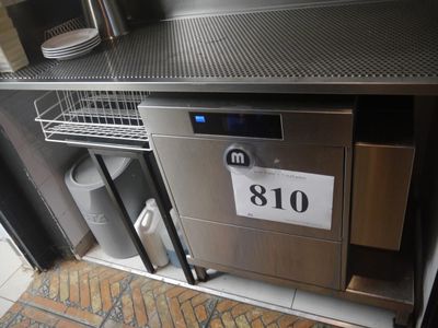 une photo d'un plan de travail en acier inoxydable sur lequel est posée une plaque d'immatriculation