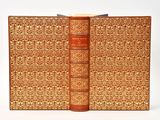 an old book with a brown cover sitting on top of a white table