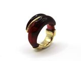 une image représentant une bague rouge et dorée sur un fond blanc