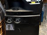 a black refrigerator with a sign on it in a warehouse