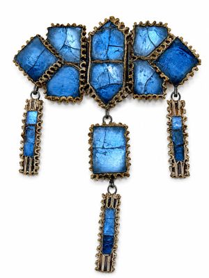 un gros plan d'un collier orné de pierres bleues sur fond blanc