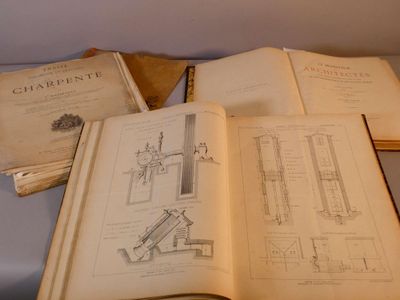 trois livres ouverts posés sur une table, sur lesquels figurent des dessins
