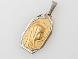 a gold and silver pendant with an image of the virgin mary
