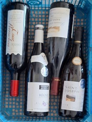 plusieurs bouteilles de vin dans un panier bleu posé sur la table