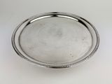 a close up of a silver plate on a white surface