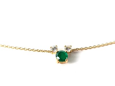 un gros plan d'un collier composé d'une pierre verte montée sur une chaîne