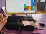 a desk with a computer, keyboard, mouse, and other items on it