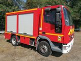 a red fire truck that is parked in the dirt
