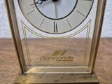 a clock that is sitting on a table in front of a wall