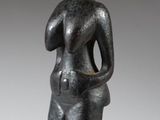 a black statue of a woman with her hands in her pockets