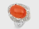 an image of a ring with an orange stone surrounded by white diamonds
