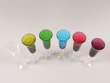 several different colored wine glasses are lined up on a white surface
