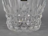 a clear glass vase with a black label on it