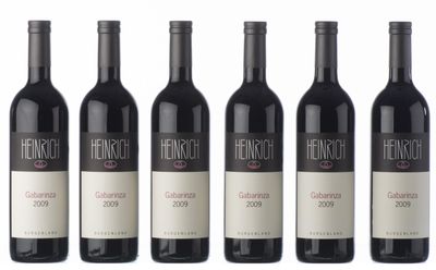 six bouteilles de vin sont alignées sur une surface blanche