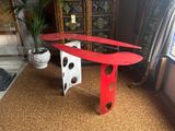 a red surfboard sitting on top of a red table