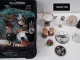 un panier noir rempli d'objets divers posé sur une table blanche