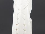 a white vase that has a statue on top of it