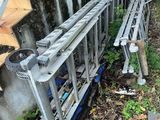 une échelle appuyée contre un mur, à côté d'un escalier
