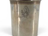 an old silver cup with a crest on the side